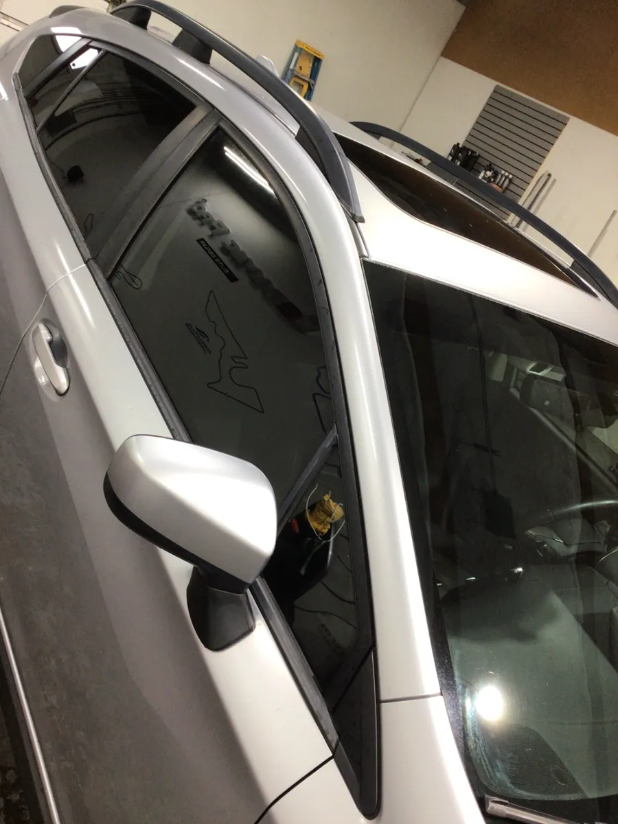 Silver Subaru Crosstrek with its front door windows tinted to match the factory rear privacy glass