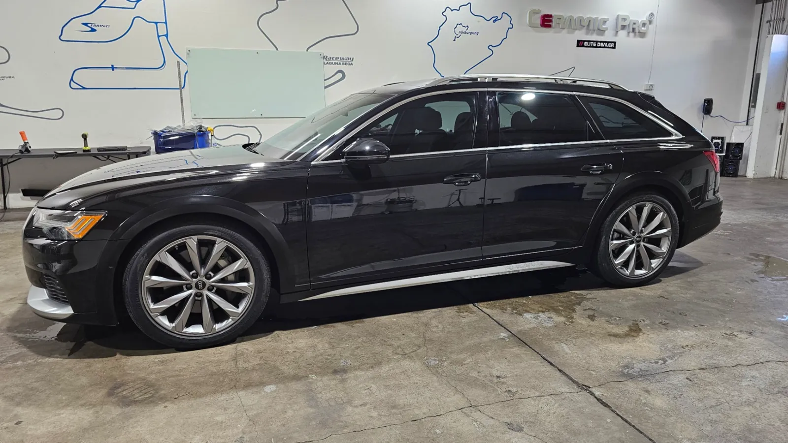 Black Audi A6 allroad wagon in the APC Auto Spa shop with tinted side windows